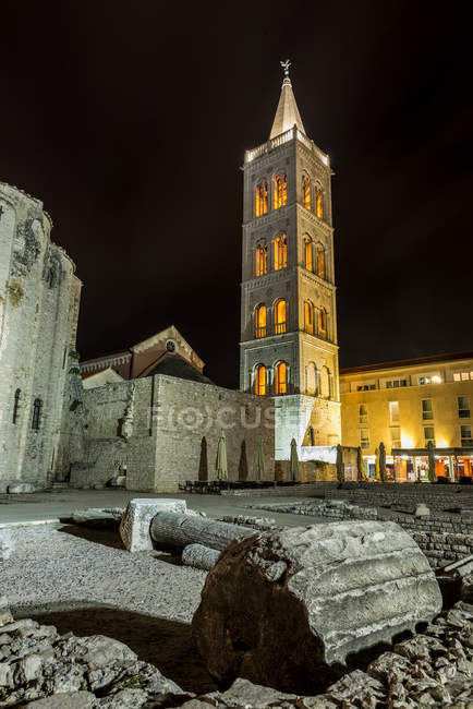 Ruinas romanas y la Torre de la Catedral de Santa Anastasia por la noche; Zadar, Croacia - foto de stock