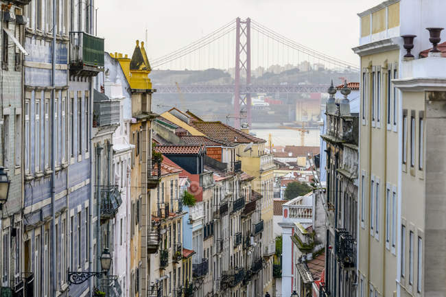 Colourful buildings in the cityscape of Lisbon, with a bridge over the Tagus; Lisbon, Lisboa Region, Portugal — Stock Photo