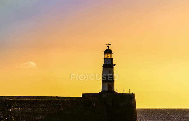 Lighthouse with golden sky at sunset; Seaham, Durham, England — Stock Photo