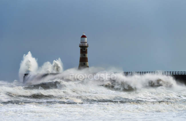 Roker Lighthouse and waves from the River Ware crash on the pier ; Sunderland, Tyne and Wear, Angleterre — Photo de stock