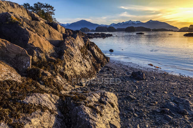 Winter sunset on rocky beach looking out over Crescent Bay; Sitka, Alaska, United States of America — Stock Photo