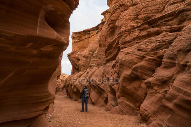 Мужчина, гуляющий в слот-каньоне, известном как Оул-Каньон, недалеко от города Пейдж, штат Аризона, Соединенные Штаты Америки — стоковое фото