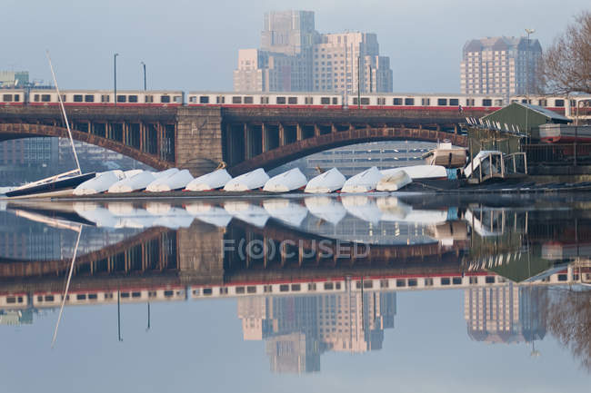 Tren en movimiento en el puente con veleros en el río, Puente Longfellow, Charles River, Boston, Condado de Suffolk, Massachusetts, EE.UU. - foto de stock