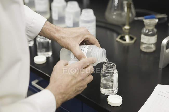 Vista de sección media de un científico que trabaja en un laboratorio - foto de stock