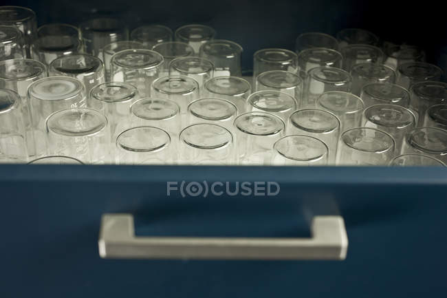 Vista de primer plano de los vasos de precipitados de laboratorio vacíos en el cajón - foto de stock