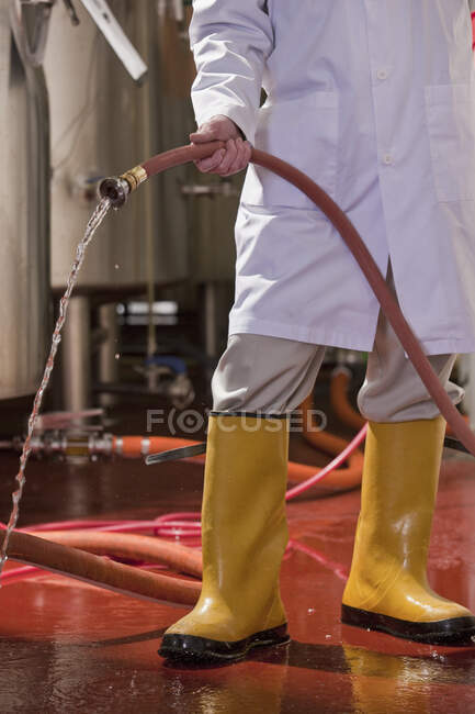 Инженер промывает пол на химическом заводе — стоковое фото
