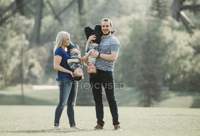 Una familia con niños pequeños jugando en un parque; Edmonton, Alberta, Canadá - foto de stock