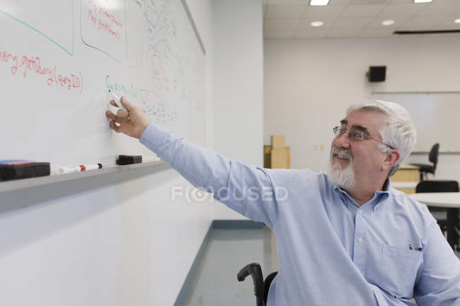 Professeur d'université avec Dystrophie musculaire enseignant dans une salle de classe — Photo de stock