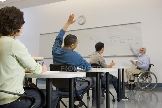 Professor universitário com Distrofia Muscular ensinando alunos em uma sala de aula — Fotografia de Stock