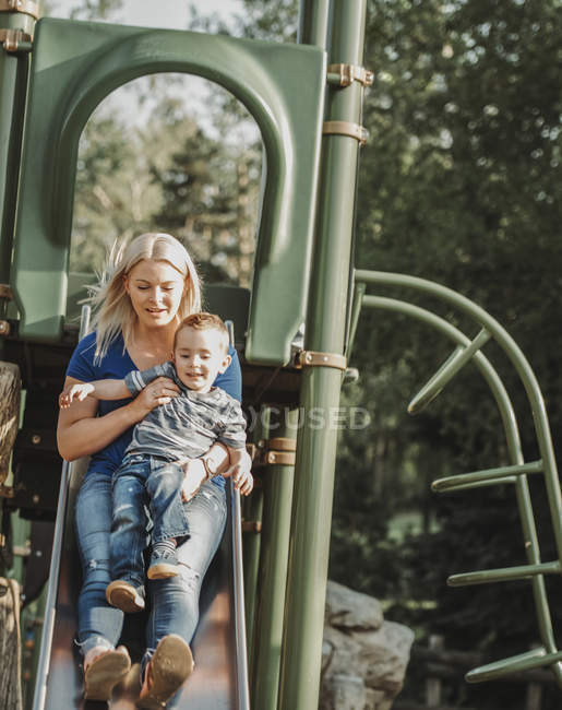 Mãe em um slide com o filho jovem; Edmonton, Alberta, Canadá — Fotografia de Stock