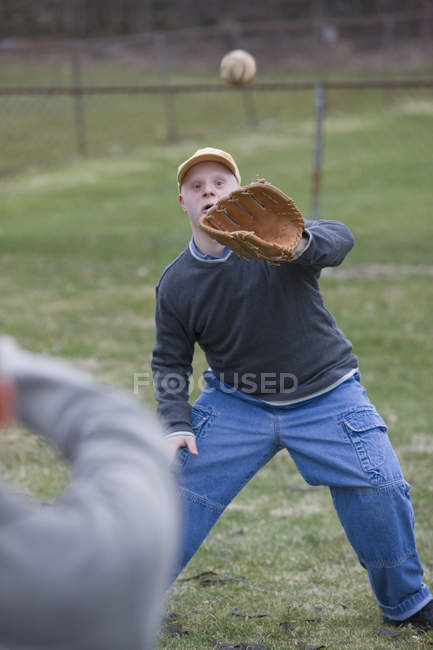 Father and son with Down Syndrome about to play baseball in park — Stock Photo