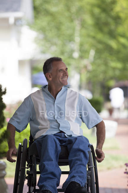 Homem com lesão medular em uma cadeira de rodas desfrutando ao ar livre — Fotografia de Stock
