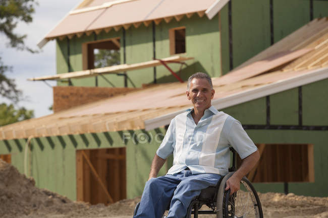 Человек с травмой спинного мозга в инвалидной коляске в своем новом доступном доме в стадии строительства — стоковое фото