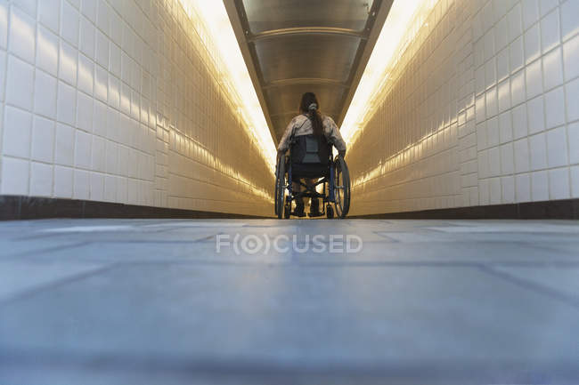 Donna con lesione del midollo spinale in sedia a rotelle che accede alla stazione della metropolitana — Foto stock