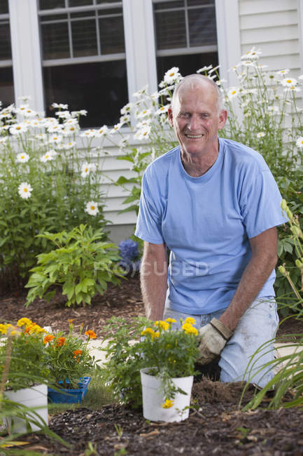 Uomo anziano che si prepara a piantare fiori nel suo giardino — Foto stock