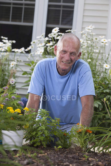 Homem sênior se preparando para plantar flores em seu jardim — Fotografia de Stock