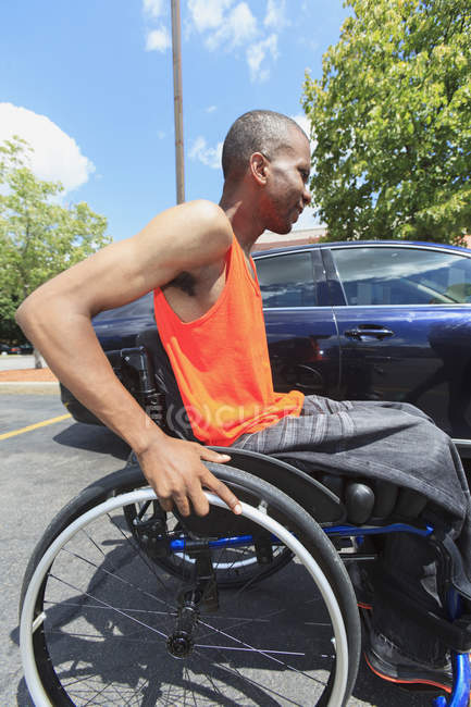 Чоловік, який мав спинний менінгіт у інвалідному візку, збирається увійти в автомобіль — стокове фото