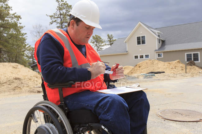 Construction engineer with spinal cord injury adjusting vise tool on site — Stock Photo