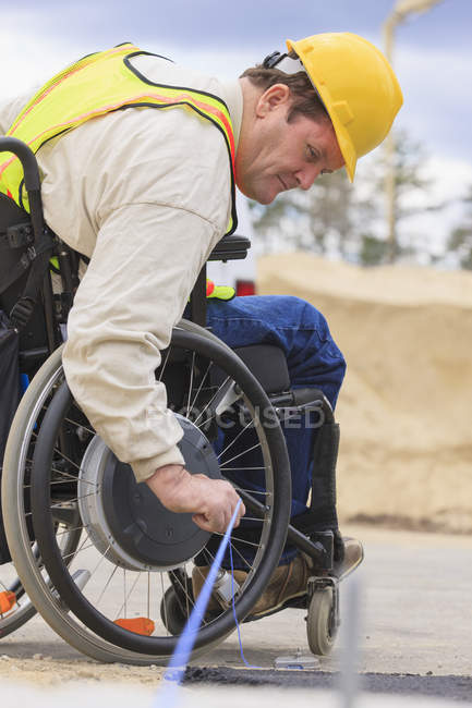 Superviseur de construction avec blessure à la moelle épinière tirant la craie au bord de la chaussée — Photo de stock