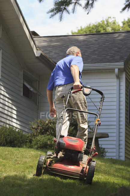Man with Cerebral Palsy and dyslexia mowing his lawn — Stock Photo