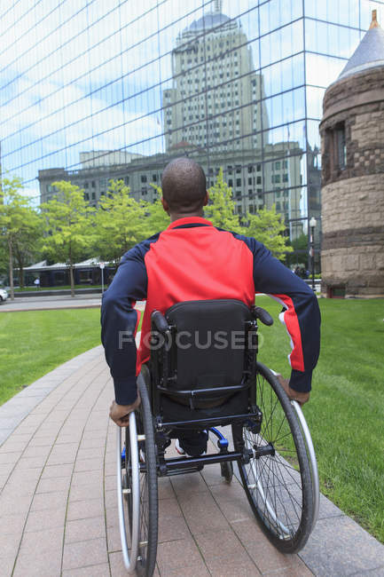 Людина в інвалідному візку, який мав спинний менінгіт, рухається самостійно в місті — стокове фото