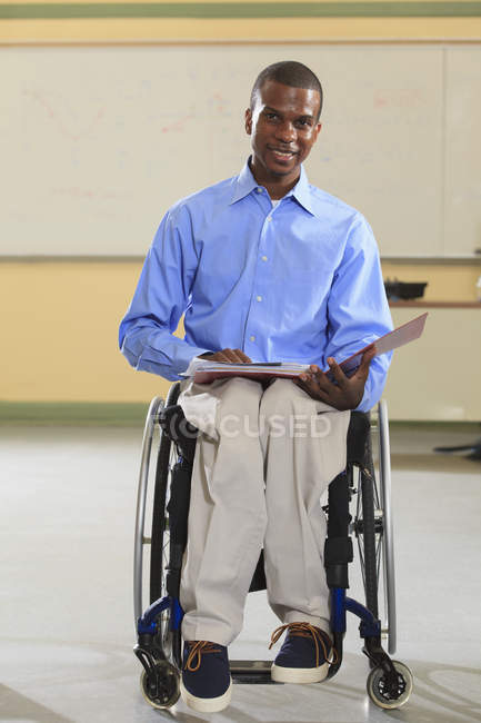 Estudiante de ingeniería en un aula de electrónica en una silla de ruedas de la meningitis espinal - foto de stock