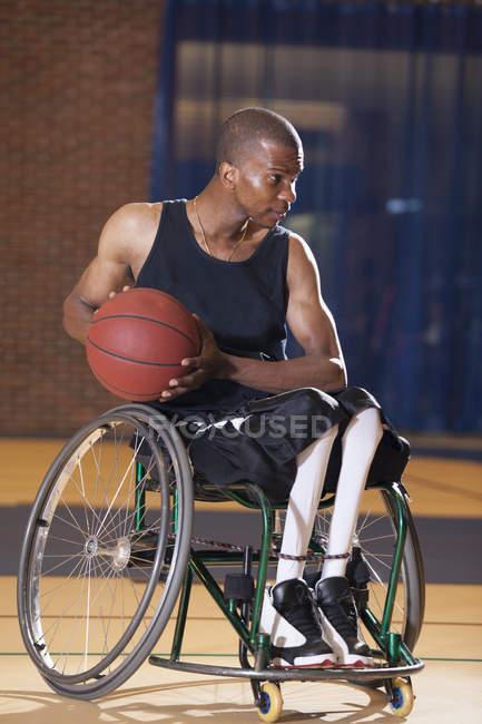 Uomo che ha avuto meningite spinale in sedia a rotelle passando pallacanestro — Foto stock