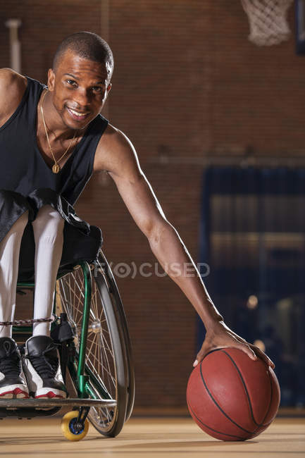 Человек, у которого был менингит позвоночника в инвалидном кресле, забирает баскетбол — стоковое фото