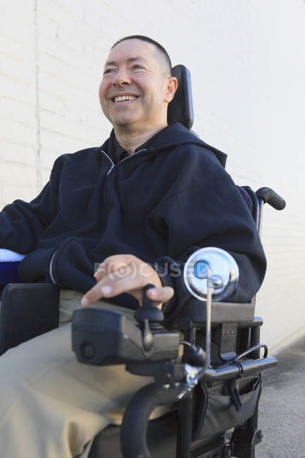 Uomo con lesione del midollo spinale con la sua sedia a rotelle motorizzata — Foto stock