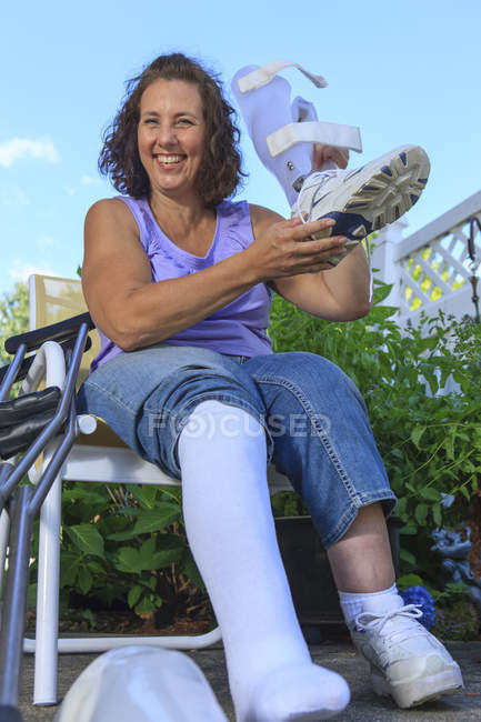 Женщина со спиной Бифида регулирует корсет для ног — стоковое фото