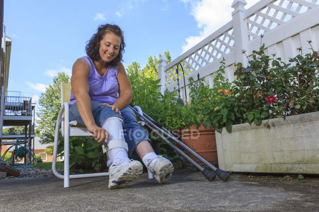 Donna con Spina Bifida che regola il tutore della gamba — Foto stock
