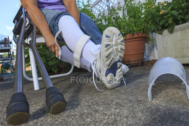 Donna con Spina Bifida che regola il tutore della gamba — Foto stock