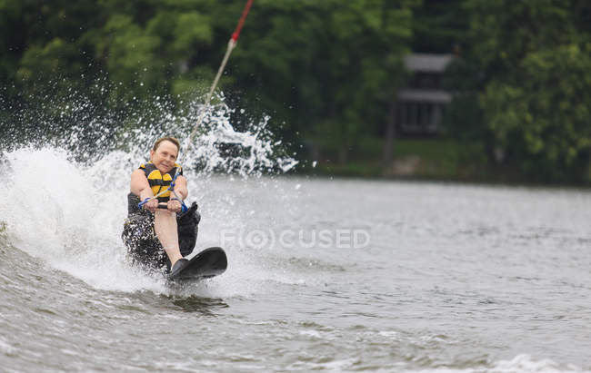 Mulher com uma perna de esqui aquático no lago — Fotografia de Stock