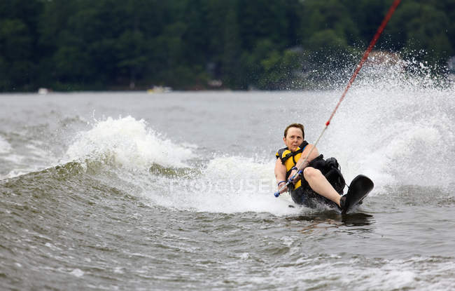 Женщина с одной ногой катается на водных лыжах по озеру — стоковое фото