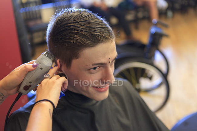 Uomo alla moda con una lesione del midollo spinale in un salone di parrucchiere ottenere un taglio di capelli — Foto stock