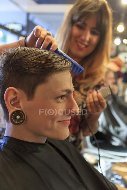Модный мужчина с травмой спинного мозга в парикмахерской, стригущий волосы — стоковое фото