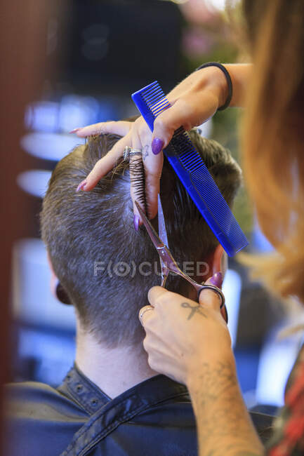 Homem com uma lesão na medula espinhal em um salão de cabeleireiro recebendo um corte de cabelo — Fotografia de Stock