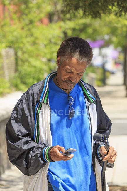 Человек с черепно-мозговой травмой с помощью мобильного телефона — стоковое фото