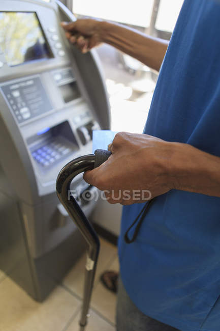Man with Traumatic Brain Injury using a bank ATM — Stock Photo