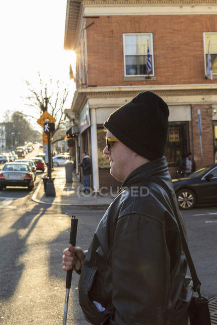 Man with congenital blindness about to cross the street using his cane — Stock Photo