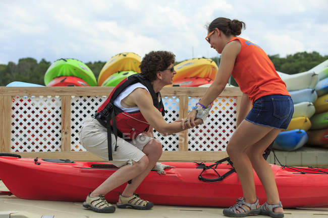 Instructor helping a woman with a Spinal Cord Injury get into a kayak — Stock Photo