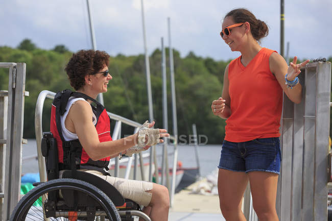 Woman with a Spinal Cord Injury talking to an instructor about using a kayak — Stock Photo