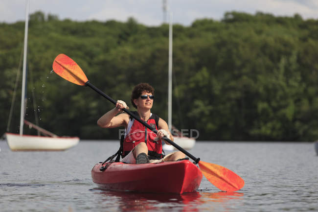 Mujer con una lesión en la médula espinal aprendiendo a usar un kayak - foto de stock