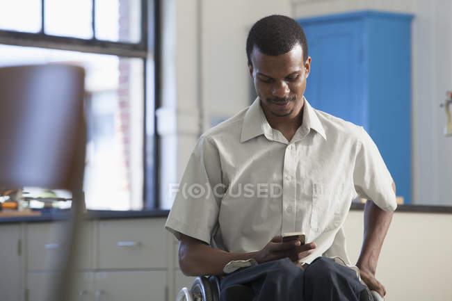 Student who had Spinal Meningitis in a science lab on his smart phone — Stock Photo