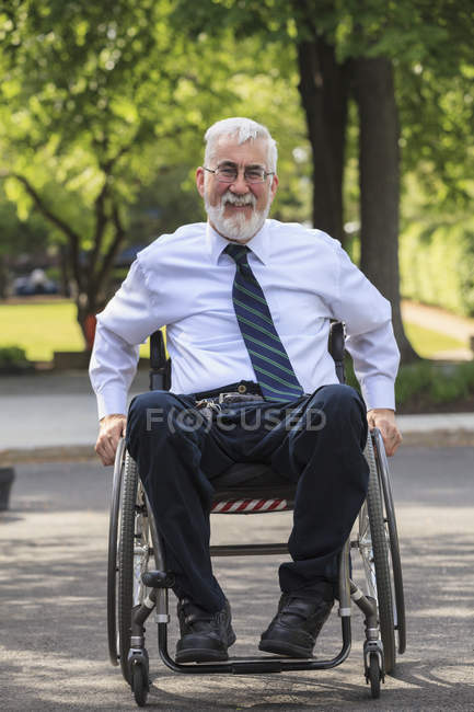 Бизнесмен с мышечной дистрофией в инвалидном кресле — стоковое фото
