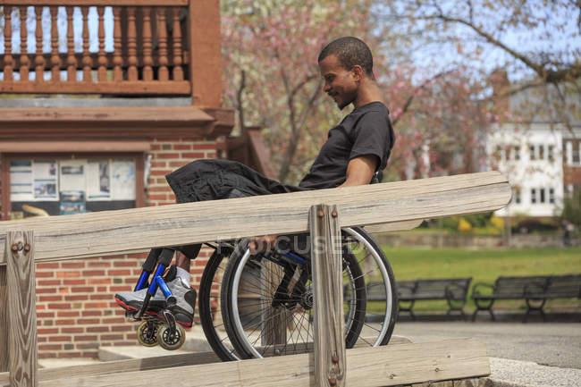 Man in a wheelchair who had Spinal Meningitis using a public building ramp — Stock Photo