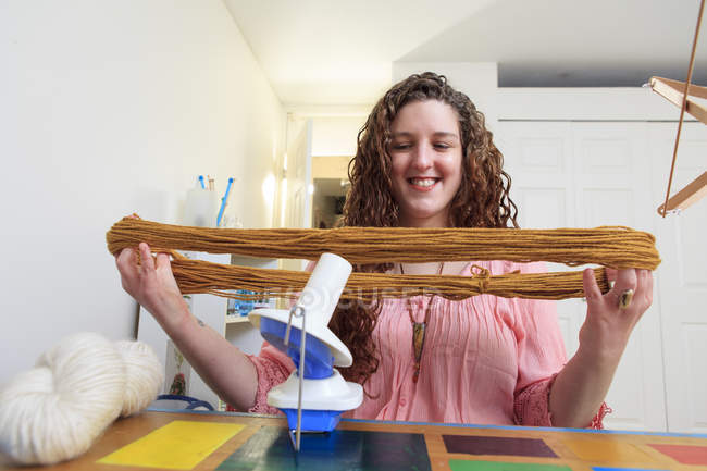Femme atteinte de dystrophie musculaire travaillant avec son fil pour son entreprise de tricot — Photo de stock