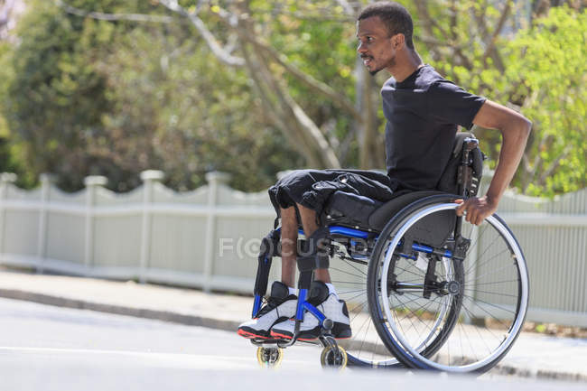 Man in a wheelchair who had Spinal Meningitis crossing the street — Stock Photo