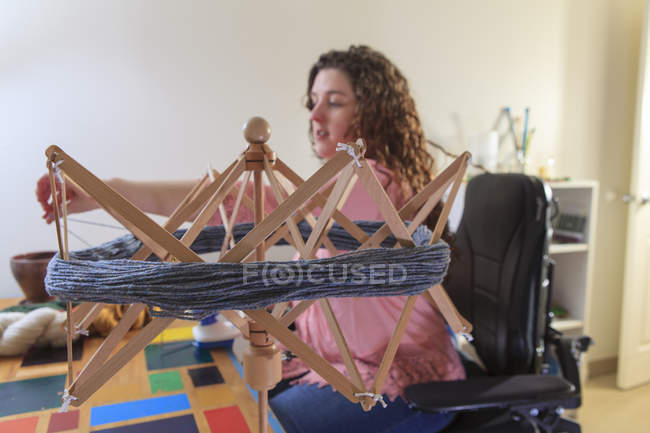 Жінка з м'язистою дистрофією, що працює з її парасольковою пряжею на її силовому стільці — стокове фото