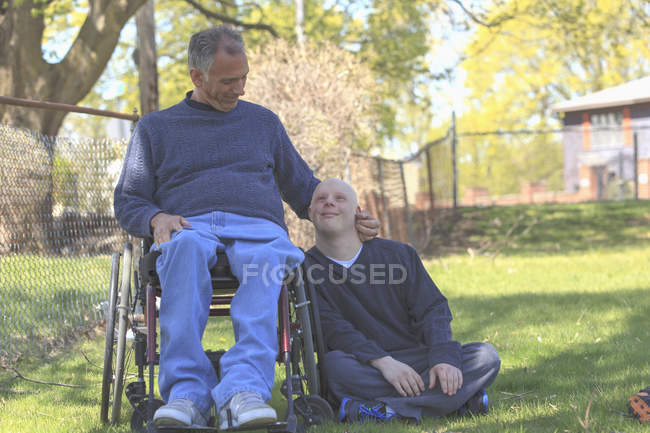 Pai com lesão medular e filho com síndrome de Down prestes a jogar beisebol no parque — Fotografia de Stock